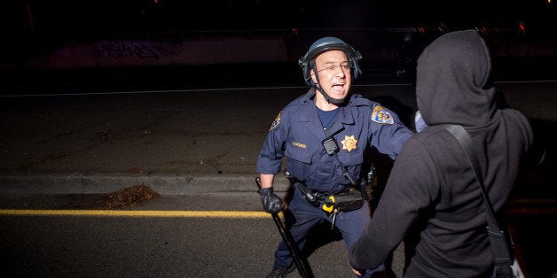 A police officer tries unsuccessfully to keep a protester from blocking Interstate 580 in Oakland, Calif on Monday, Nov. 24, 2014, after the announcement of the grand jury decision not to indict Ferguson police officer Darren Wilson in the fatal shooting of Michael Brown, an unarmed 18-year-old. (AP Photo/Noah Berger)