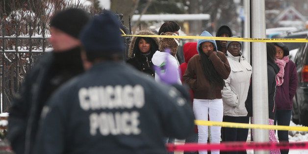 CHICAGO, IL - DECEMBER 15: Neighborhood residents watch as police investigate a homicide scene after a 24-year-old man was found dead with a gunshot to his back in the Lawndale neighborhood on December 15, 2013 in Chicago, Illinois. At around 7:30 a.m. someone reported finding the body lying on a sidewalk. Residents at the scene reported hearing gunshots around 3:00 a.m.. Chicago has had more than 400 homicides in 2013. Last year the city reported more than 500. ( Photo by Scott Olson/Getty Images )