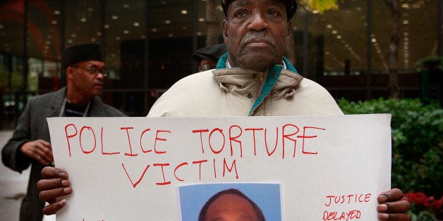 CHICAGO - OCTOBER 27: Aaron Cheney demonstrates outside the federal courthouse where former Chicago Police Commander Jon Burge was attending a hearing on charges he obstructed justice and committed perjury for lying while under oath during a 2003 civil trial about decades-old Chicago police torture allegations October 27, 2008 in Chicago, Illinois. Burge cannot be charged for the torture of suspects because the federal statute of limitations for the crime has expired. (Photo by Scott Olson/Getty Images)