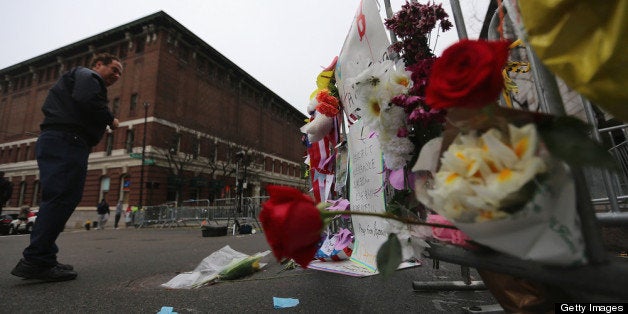 BOSTON, MA - APRIL 23: A man views a makeshift memorial at a barricade blocking a still closed section of Boylston Street ne