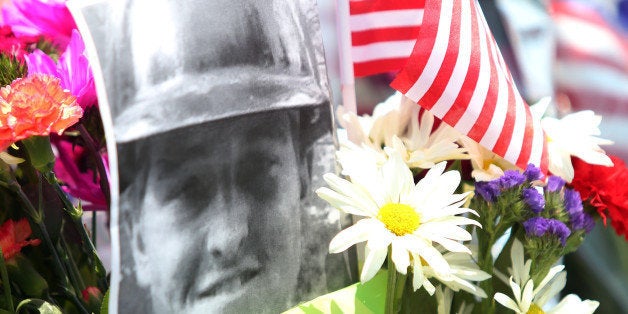 A fallen firefighter's picture is part of a memorial outside of the Granite Mountain Hotshot fire station in Prescott, Arizona July 1, 2013. Reinforcements poured in Monday to battle a runaway wildfire which quadrupled in size overnight after killing 19 firefighters in one of the worst such incidents in US history. The Yarnell Hill fire -- which killed all but one member of a 20-strong 'hotshot' team -- was the biggest loss of firefighters' lives since the September 11 attacks, and the most from a US wildfire in 80 years. AFP PHOTO / KRISTA KENNELL (Photo credit should read Krista Kennell/AFP/Getty Images)