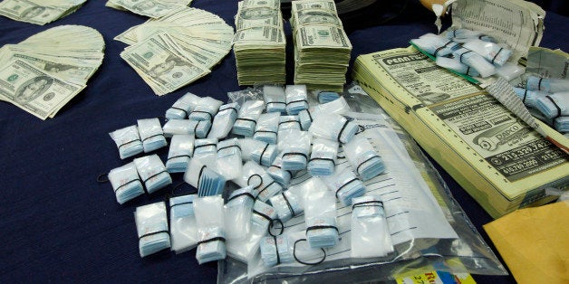 Confiscated money, heroin and a weapon are displayed at a news conference in Philadelphia on Friday, April 8, 2011. Pennsylva