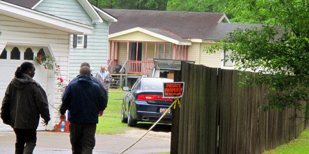 Investigators work at a scene of a shooting in Hollywood, S.C., Thursday, May 7, 2015. A sheriff's deputy responding to a home invasion shot the homeowner in the neck Thursday because he refused to drop his gun, authorities said. (AP Photo/Bruce Smith)