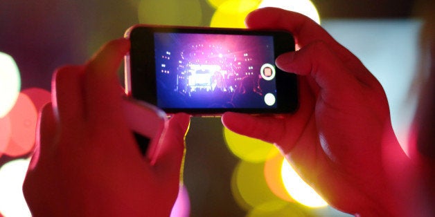 Man used mobile phone camera take pictures in the Concert party