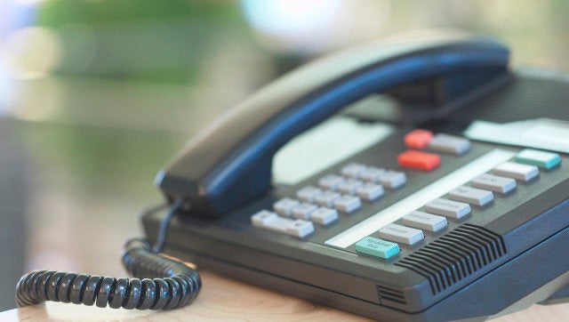 Business telephone with extensions on desk in office