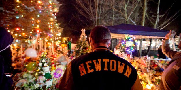 Greg Frattaroli, 19, of Newtown, Conn., visits a memorial for the Sandy Hook Elementary School shooting victims, Tuesday, Dec. 18, 2012, in Newtown, Conn. (AP Photo/David Goldman)