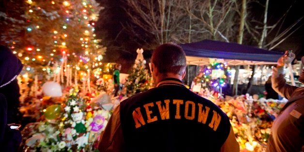 Greg Frattaroli, 19, of Newtown, Conn., visits a memorial for the Sandy Hook Elementary School shooting victims, Tuesday, Dec