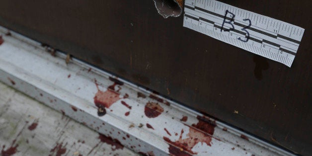 Blood is seen by a side doorway, Tuesday, Aug. 6, 2013, where a shooting occurred Monday night at the Ross Township Municipal
