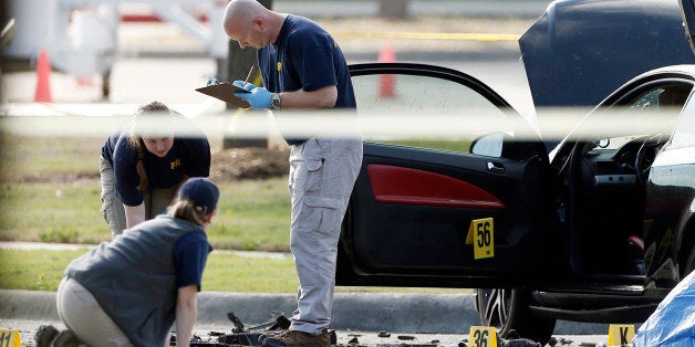 FBI crime scene investigators document the area around two deceased gunmen and their vehicle outside the Curtis Culwell Center in Garland, Texas, Monday, May 4, 2015. Police shot and killed the men after they opened fire on a security officer outside the suburban Dallas venue, which was hosting provocative contest for Prophet Muhammad cartoons Sunday night, authorities said. (AP Photo/Brandon Wade)