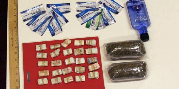 In this undated photo provided by the New York City Department of Investigation, contraband smuggled by an undercover investigator into Rikers Island jail facilities is shown. During six visits to the New York City jail, the investigator was able to get a plastic bag containing 250 glassine envelopes of heroin; one plastic bag containing 24 packaged strips of suboxone; two plastic bags containing a total weight of one half-pound of marijuana, 16 ounces of vodka in a water bottle, and one razor blade past the personnel at the security entrance. (AP Photo/New York City Department of Investigation)