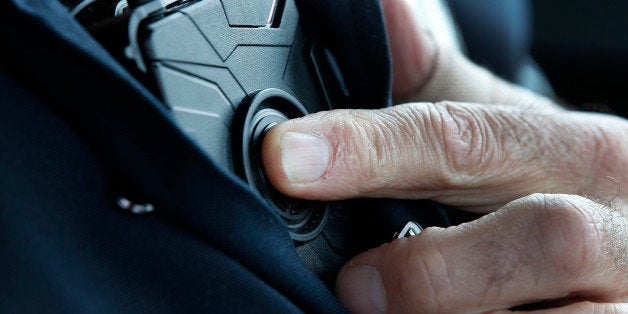 WEST VALLEY CITY, UT - MARCH 2: West Valley City patrol officer Gatrell starts a body camera recording by pressing a button on his chest before he takes a theft report from a construction worker with his newly-issued body camera attached to the side of a pair of glasses on March 2, 2015 in West Valley City, Utah. West Valley City Police Department has issued 190 Taser Axon Flex body cameras for all it's sworn officers to wear starting today. (Photo by George Frey/Getty Images)