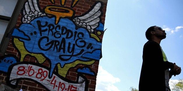 BALTIMORE, MD - MAY 03: A man looks to the sky near a Freddie Gray memorial tagging two days after Baltimore authorities rele
