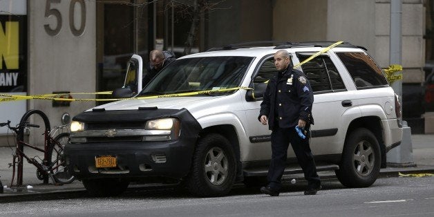 New York City Police officers work the scene of a shooting at a Home Depot, Sunday, Jan. 25, 2015, in New York. Police said a