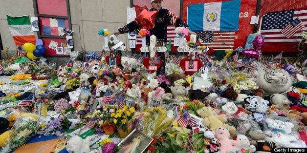 BOSTON, MA - APRIL 22: Kevin Brown, who made some of the memorial wooden crosees for the victims, observes a moment of silence at a makeshift memorial near the finish line of the Boston Marathon bomings on one week anniversary of the bombings on April 22, 2013 in Medford, Massachusetts. A manhunt ended for Dzhokhar A. Tsarnaev, 19, a suspect in the Boston Marathon bombing after he was apprehended on a boat parked on a residential property in Watertown, Massachusetts. His brother Tamerlan Tsarnaev, 26, the other suspect, was shot and killed after a car chase and shootout with police. The bombing, on April 15 at the finish line of the marathon, killed three people and wounded at least 170. (Photo by Kevork Djansezian/Getty Images)