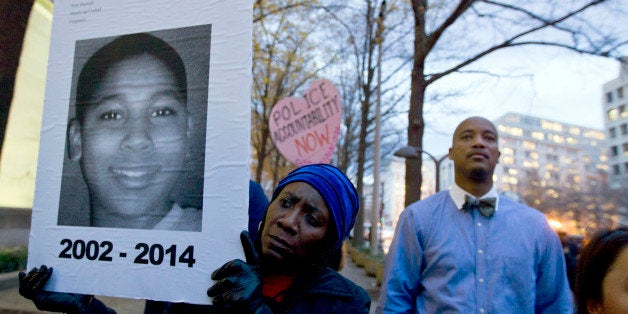 CORRECTS THE ID OF THE MALE ON POSTER TO TAMIR RICE - Tomiko Shine holds up a picture of Tamir Rice, the 12 year old boy fata