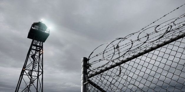 Security tower and razor wire-topped fence
