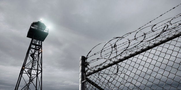 Security tower and razor wire-topped fence