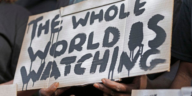 A man holds a sign during a protest for the shooting death of Walter Scott at city hall in North Charleston, S.C., Wednesday, April 8, 2015. Scott was killed by a North Charleston police officer after a traffic stop on Saturday. The officer, Michael Thomas Slager, has been charged with murder. (AP Photo/Chuck Burton)