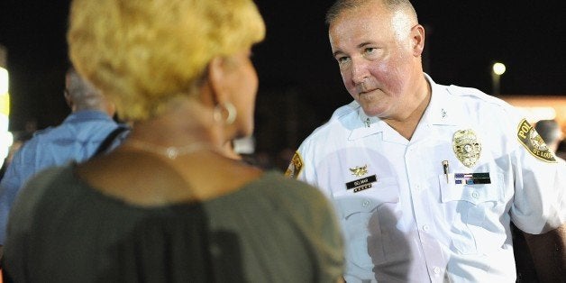 Chief Jon Belmar (R) of the St. Louis County Police department speaks to demonstrators during a peaceful protest on West Flo