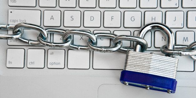 Close-up of padlock and chain around laptop computer