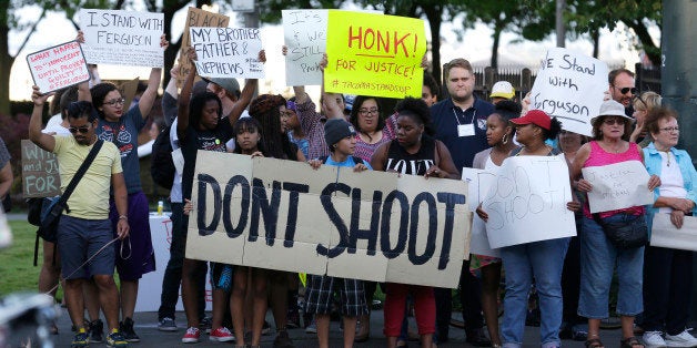 Protesters hold a sign that reads "Don't Shoot" as they attend an evening rally Tuesday, Aug. 19, 2014, in Tacoma, Wash. Several hundred people attended the peaceful gathering to show support for protesters in Ferguson, Missouri, where the fatal shooting of 18-year-old Michael Brown has sparked nightly clashes between protesters and police. (AP Photo/Ted S. Warren)