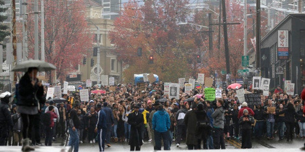 Protesters march in downtown Seattle, Tuesday, Nov. 25, 2014, to demonstrate against a grand jury's decision not to indict police officer Darren Wilson in the killing of Michael Brown. The peaceful march was a mix of students who walked out of schools and a coalition of clergy members. (AP Photo/Ted S. Warren)