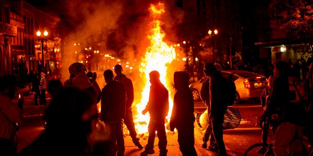 Protesters gather around burning refuse in Oakland, Calif., on Tuesday, Nov. 25, 2014, after the announcement that a grand jury decided not to indict Ferguson police officer Darren Wilson in the fatal shooting of Michael Brown, an unarmed 18-year-old. Several thousand protesters marched through Oakland with some shutting down freeways, looting, burning garbage and smashing windows. (AP Photo/Noah Berger)