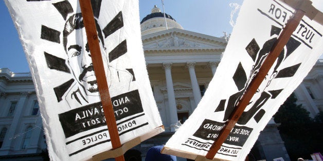 Signs bearing the likeness of police shooting victims Andres Avila, left, and Jose De La Trinidad were displayed at a rally calling for the end of police brutality held at the Capitol Sacramento, Calif., Tuesday, Oct. 22, 2013. Calling it an epidemic of police brutality, organizers of the demonstration called for the drug testing of officers after officer-involved shootings, for body cameras to be worn by every officer, and other demands. Andres Avila, 26, was shot and killed by Pomona Police in Oct. 2011 and De La Trinidad, 36, was shot and killed by a Los Angeles County Deputy Sheriff's deputies in Nov. 2012. (AP Photo/Rich Pedroncelli)