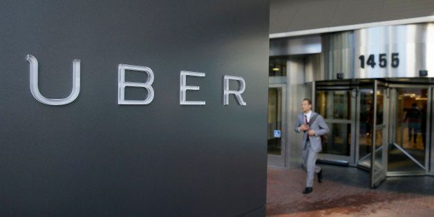 In this photo taken Tuesday, Dec. 16, 2014, a man leaves the headquarters of Uber in San Francisco. (AP Photo/Eric Risberg)