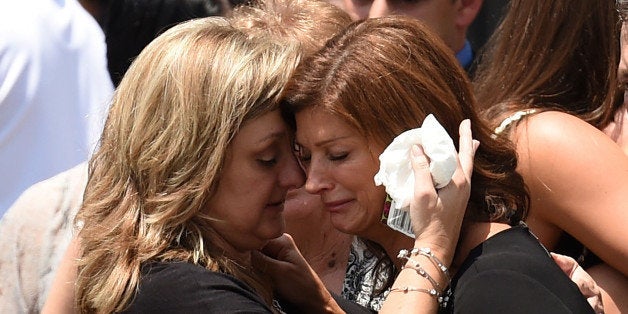 FRANKLIN, LA - JULY 27: Dondie Breaux (R), mother of Maycie Breaux, is consoled outside of the Church of the Assumption on July 27, 2015 in Franklin, Louisiana. Two people were killed and nine wounded when a shooter identified as John Russell Houser, 59, opened fire in a theater before killing himself, according to police. (Photo by Stacy Revere/Getty Images)