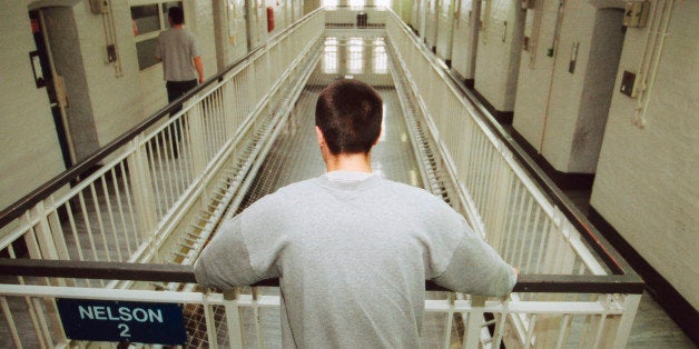 Inmate looking over barrier on prison wing, Portland Young Offenders Institution, Dorset, UK. (Photo by: Photofusion/UIG via