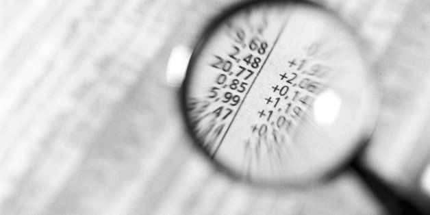 Financial numbers under magnifying glass, close-up, b&w