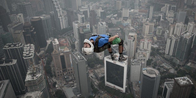 Base jumper Denis Odintsov from Russian leaps from the 300-metres Open Deck of the Malaysia's landmark Kuala Lumpur Tower during the International Tower Jump in Kuala Lumpur on September 27, 2013. Some 103 professional base jumpers from 20 countries are taking part in the annual event. AFP PHOTO / MOHD RASFAN (Photo credit should read MOHD RASFAN/AFP/Getty Images)