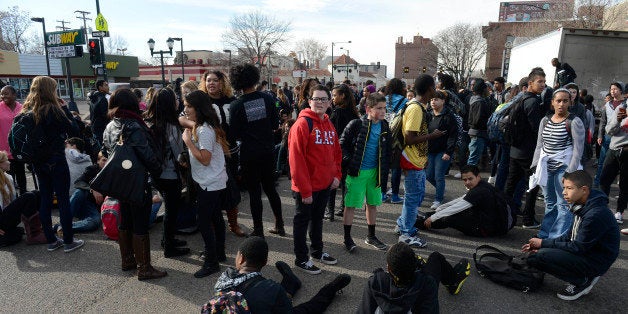 DENVER, CO - DECEMBER 03: East High School students gather and sit in the intersection of York St and Colfax Ave during a Ferguson walkout and protest only a few block east of where four Denver Police officers on bicycles were hit by a vehicle traveling west on Colfax. All of the officers were transported to Denver Health Medical center December 03, 2014 with unknown conditions. (Photo by Andy Cross/The Denver Post via Getty Images)