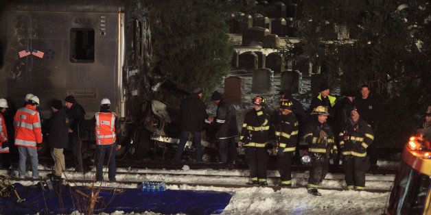 Emergency personnel work at the scene of a Metro-North Railroad passenger train and a vehicle accident in Valhalla, N.Y., Tuesday, Feb. 3, 2015. A packed commuter train slammed into a sport utility vehicle stuck on the tracks and erupted into flames, authorities said. (AP Photo/Robert Mecea)