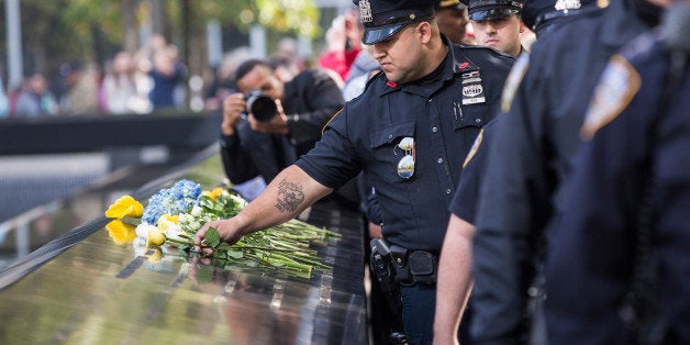 NEW YORK, NY - OCTOBER 22: Law enforcement officials lay flowers in tribute to slain New York Police Department officer Randolph Holder at National September 11th Memorial on October 22, 2015 in New York City. Holder was killed on Tuesday evening while in pursuit of a suspect. (Photo by Andrew Burton/Getty Images)