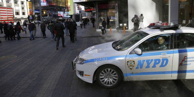 FILE. In this Jan. 8, 2015 file photo, a policeman looks out the window of his patrol car in Times Square in New York. In bustling Times Square, where scores of tourists wander through streets clogged with traffic and hawkers selling trinkets, low-level enforcement activity has all but grinded to a halt. The slowdown is happening city wide, but itￃﾢￂﾀￂﾙs unclear whether itￃﾢￂﾀￂﾙs a blip or the new status quo and what it means for the broken windows style of policing. (AP Photo/Seth Wenig, File)