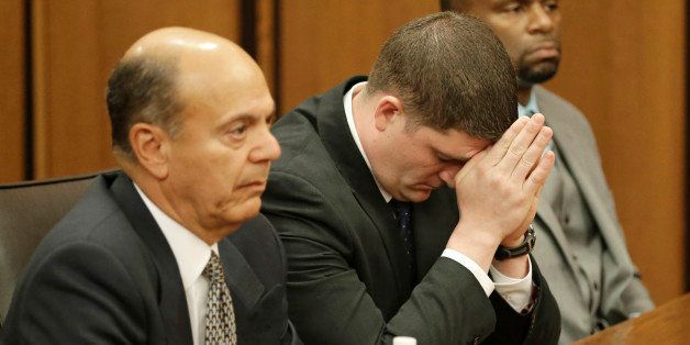 Michael Brelo, center, listens to the judge reading his verdict during his trial Saturday, May 23, 2015, in Cleveland. Brelo, a patrolman charged in the shooting deaths of two unarmed suspects during a 137-shot barrage of gunfire was acquitted Saturday in a case that helped prompt the U.S. Department of Justice determine the city police department had a history of using excessive force and violating civil rights. Seated next to Brelo is attorney Patrick DￃﾢￂﾀￂﾙAngelo, left, and attorney Fernando Mack. (AP Photo/Tony Dejak)