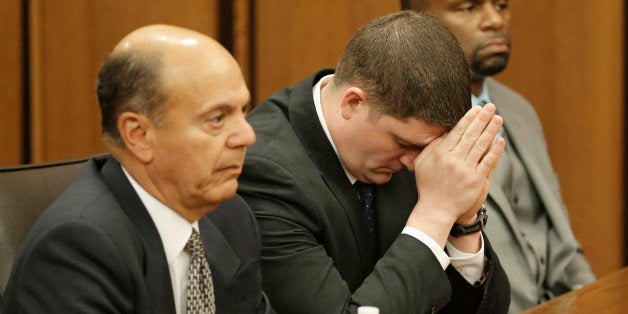 Michael Brelo, center, listens to the judge reading his verdict during his trial Saturday, May 23, 2015, in Cleveland. Brelo,