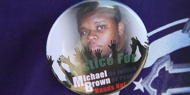 FERGUSON, MO - AUGUST 13: A resident wears a button featuring a picture of Michael Brown during a press conference with Police Chief Thomas Jackson who was fielding questions related to the shooting death of Brown on August 13, 2014 in Ferguson, Missouri. Brown was shot and killed by a Ferguson police officer on Saturday. Ferguson has experienced three days of violent protests since the killing. (Photo by Scott Olson/Getty Images)