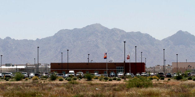 Vehicles are parked outside the La Palma Correctional Center in Eloy, Arizona, U.S., on Tuesday, May 11, 2010. La Palma, which houses about 2,900 convicts from California, is one of 65 facilities operated by Corrections Corp. of America, the largest private-prison operator in the U.S. Photographer: Joshua Lott/Bloomberg via Getty Images