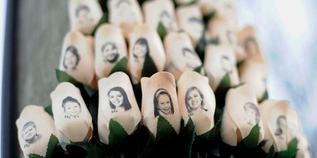 FILE - In this Jan. 14, 2013 file photo, white roses with the faces of victims of the Sandy Hook Elementary School shooting a