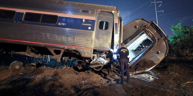 Emergency personnel work the scene of a deadly train wreck, Tuesday, May 12, 2015, in Philadelphia. An Amtrak train headed to New York City derailed and crashed in Philadelphia. (AP Photo/ Joseph Kaczmarek)