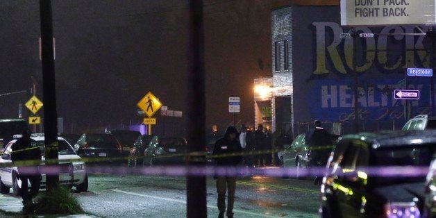 Police stand outside the scene of a multiple shooting near Rockie's Barber Shop in Detroit, Wednesday, Nov. 6, 2013. Detroit police say gunfire broke out at the barbershop known for gambling activity. Police Chief James Craig told reporters that police were looking for two vehicles that the suspects may have been using, a 2004 white Chevrolet Impala that may have a broken window and bullet holes in the back, and a 2004 black Impala. (AP Photo/Carlos Osorio)