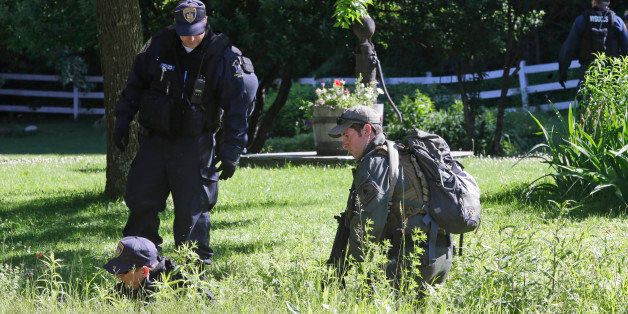 New York State Department of Corrections Officers and a forest ranger, right, patrol an area in Owls Head, N.Y. for convicted murderers Richard Matt and David Sweat, Friday, June 26, 2015. Police shifted a focus of their three week search closer to the Canadian border. (AP Photo/Mary Altaffer)