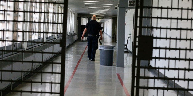 A Rikers Island juvenile detention facility officer walks down a hallway of the jail, Thursday, July 31, 2014, in New York. (AP Photo/Julie Jacobson)