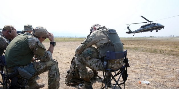 FBI agents take cover as a Blackhawk helicopter lands at the Cascade Airport in Cascade, Idaho, during the search for James D