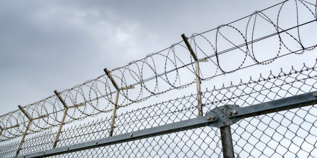 wired fence with barbed wires on blue sky background
