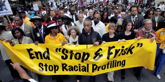 FILE - In this June 17, 2012, file photo, the Rev. Al Sharpton, center, walks with demonstrators during a silent march to end New York's "stop-and-frisk" program. On Aug. 12, 2013, a federal judge sitting in New York said the department made thousands of racially discriminatory street stops and appointed a monitor to direct changes. (AP Photo/Seth Wenig, File)