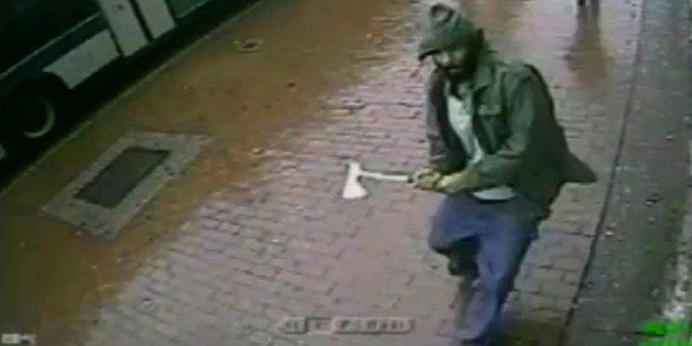 In this frame grab taken from video provided by the New York Police Department, an unidentified man approaches New York City police officers with a hatchet, Thursday, Oct. 23, 2014, in the Queens borough of New York. The man injured two with the hatchet before the other officers shot and killed him, police said. A bystander was wounded in the gunfire. Investigators were still trying to confirm the identity of the assailant and determine a motive. (AP Photo/New York Police Department)